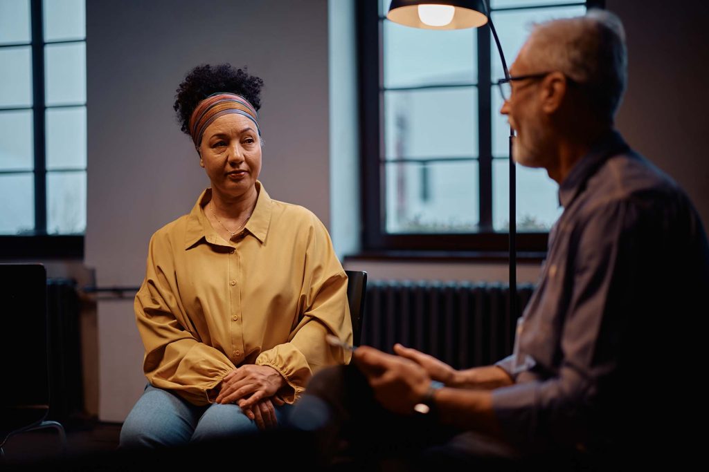 mature woman participating in group therapy meetin 94ZCSXP